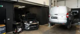 Ford Fiesta ST and Ford Transit Courier being serviced on a two-post ramp inside the Pro Tuning workshop in Bournemouth